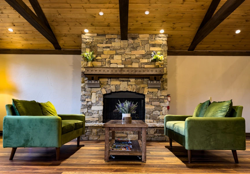 Uplift Wellness & Aesthetics cozy lounge area with stone fireplace and comfortable seating